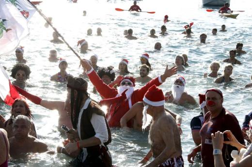 A man dressed as a Santa Claus takes part in the traditional Christmas bath during an unusually warm winter day in Nice, southeastern France, December 20, 2015. REUTERS/Eric Gaillard