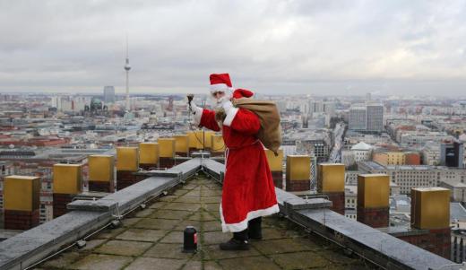 A man dressed as a Santa Claus poses on top of the Kollhoff Tower at Potsdamer Platz square in Berlin, Germany, December 13, 2015 REUTERS/Fabrizio Bensch